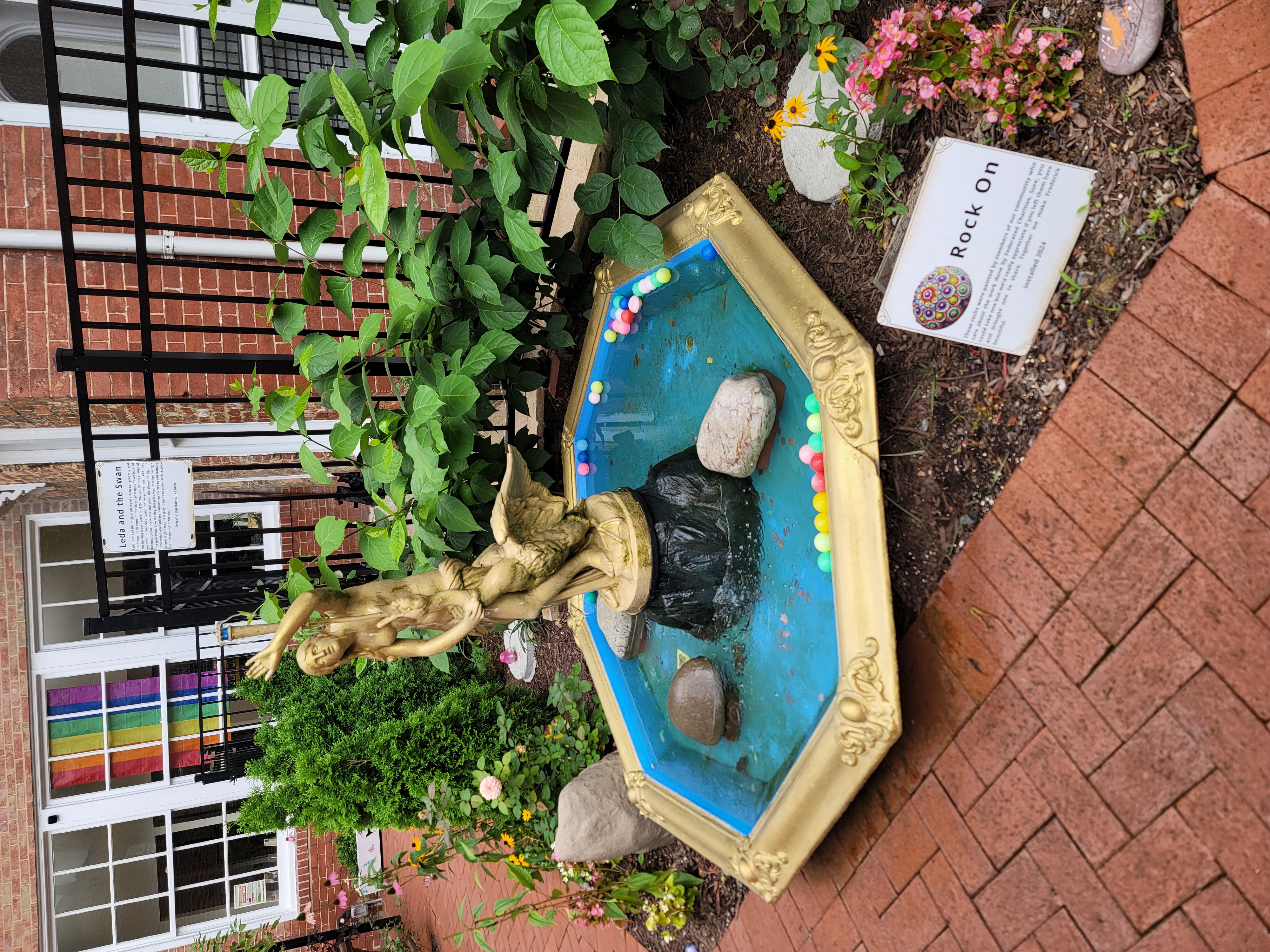 a water fountain with a golden painted statue of a person and a waterfowl